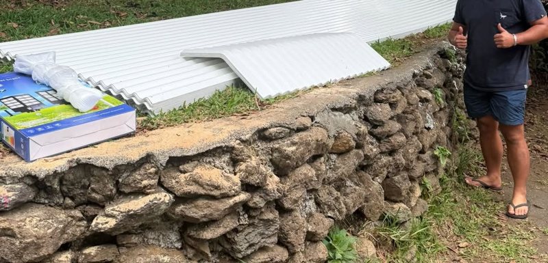 Tôles et faîtière blanches livrées dans un jardin à Tahiti
